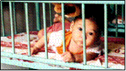 Orphaned child in iron crib.  